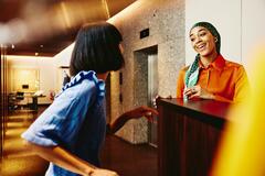 Smiling hotel receptionist helping a guest.