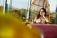 Woman sitting down while talking on the phone.