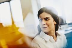 Woman in a white shirt in an office. Primary color: yellow.