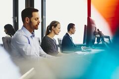 People working in their desks. Primary colors: blue and red.