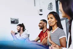 Four people having a conversation in a meeting room at an office.
