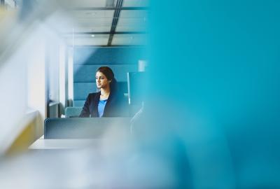 Woman sitting at her desk. India. Primary color: blue.