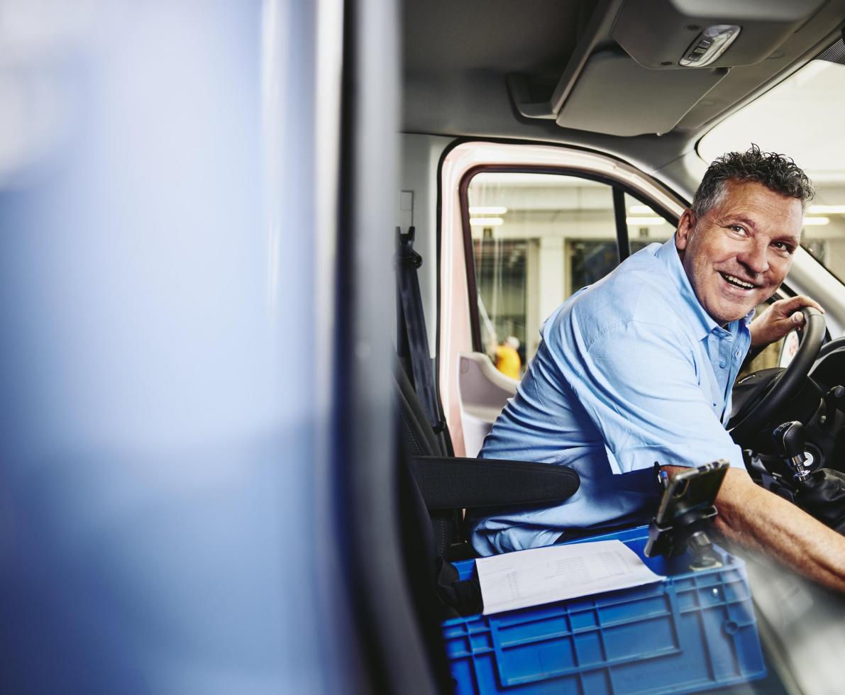Smiling man sitting in driver's seat of a logistics truck Smiling man sitting in driver's seat of a logistics truck