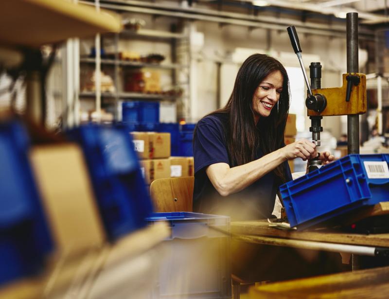 Smiling woman working on a production site.